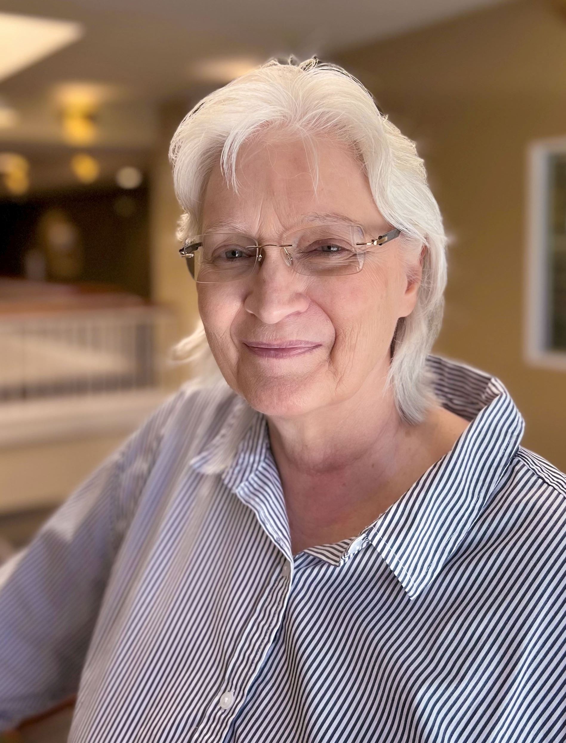 Picture of a woman in an office setting smiling at the camera