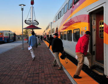 People Boarding and Exiting the Rail Runner with a Bus Connection